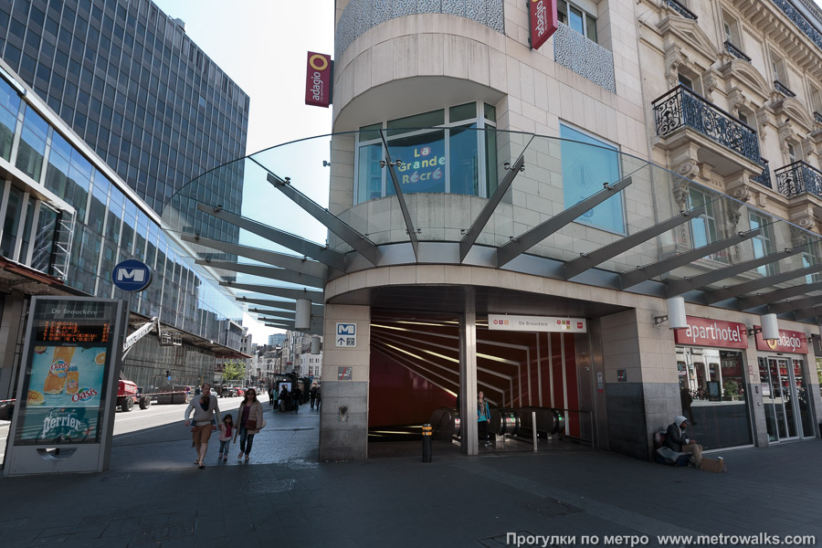 Станция De Brouckère [Дё Бруке́р] (линия 1, Брюссель). Вход на станцию через подземный переход, спуск в который встроен в здание. На перекрёстке бульвара Анспаш с Епископской улицей.