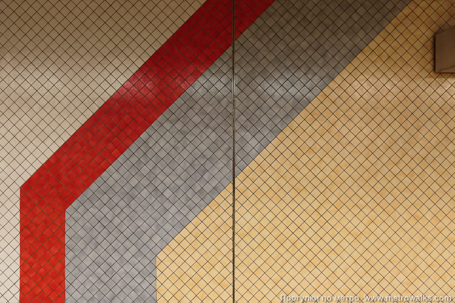 Станция Hôtel des Monnaies / Munthof [Отэ́ль де Монэ́ / Мюнтхоф] (линия 2 / 6, Брюссель). Станционные стены облицованы мелкой плиткой квадратной формы, образующей орнаменты простых геометрических форм.