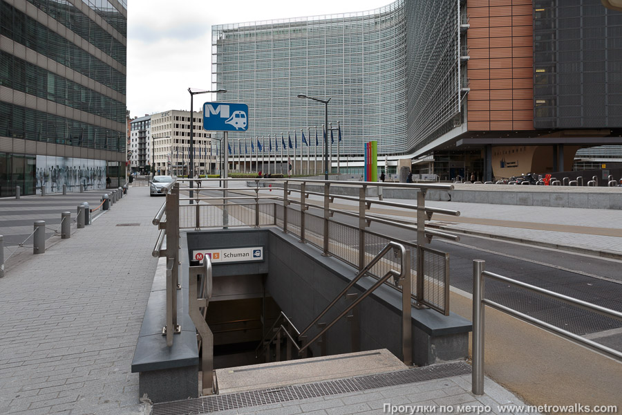 Станция Schuman [Шу́ман] (линия 1, Брюссель). Вход на станцию осуществляется через подземный переход. На заднем плане — здание «Берлемон», штаб-квартира Европейской комиссии.