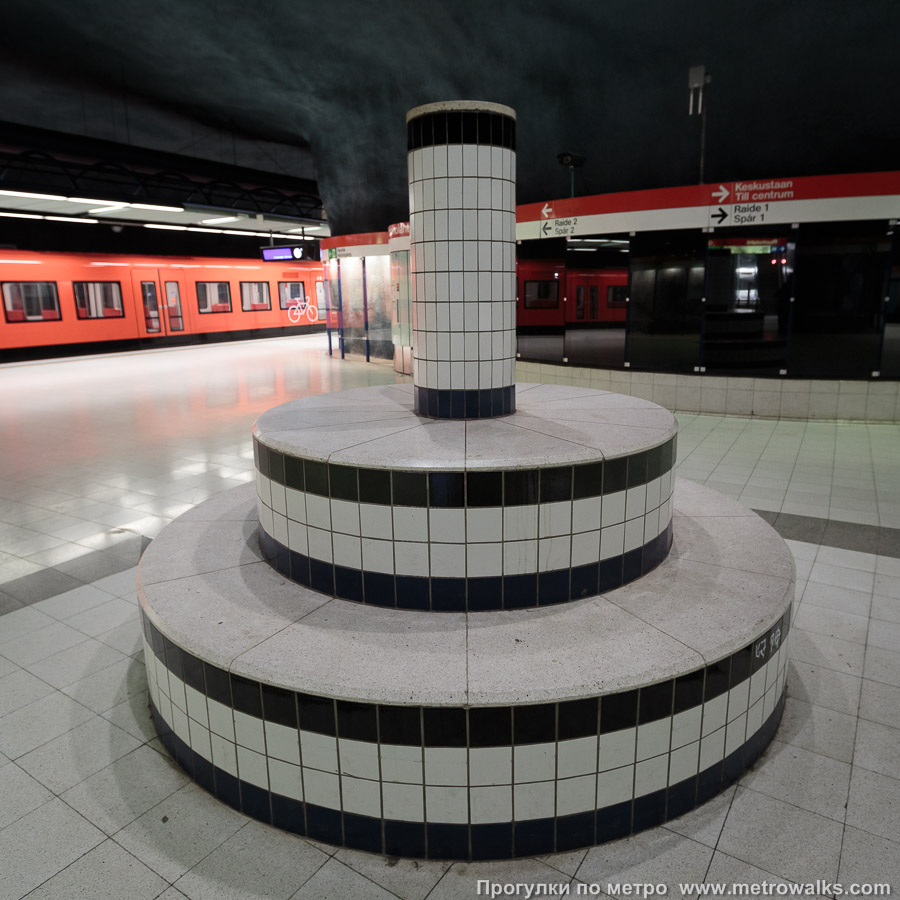 Станция Ruoholahti / Gräsviken [Руо́хола́хти] (Хельсинки). В центре станции установлена скульптура из трёх бетонных цилиндров, придающая станции стиль средневековой площади. Скульптор — Juhana Blomstedt.
