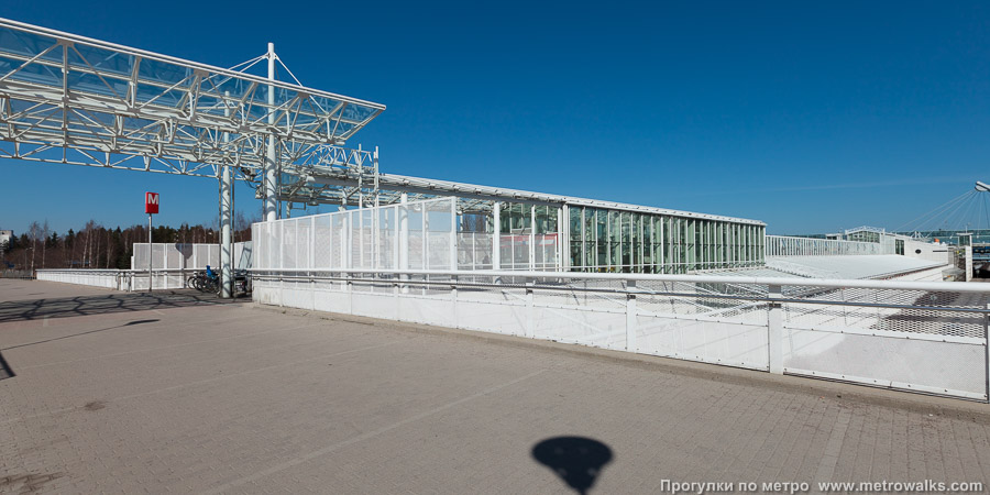 Станция Vuosaari / Nordsjö [Вуо́саа́ри] (Хельсинки). Вестибюль западного (дополнительного) входа в солнечный весенний день.