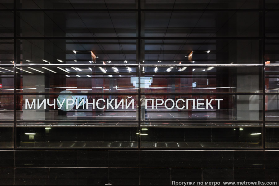 Станция Мичуринский проспект (Солнцевская линия, Москва). Название станции на путевой стене крупным планом. На стеклянной стороне станции.