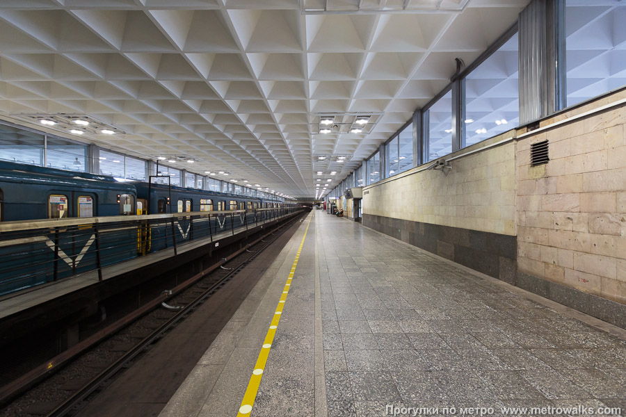 Станция Девяткино (Кировско-Выборгская линия, Санкт-Петербург). Продольный вид вдоль края платформы. Для пущей цветастости — с поездом.