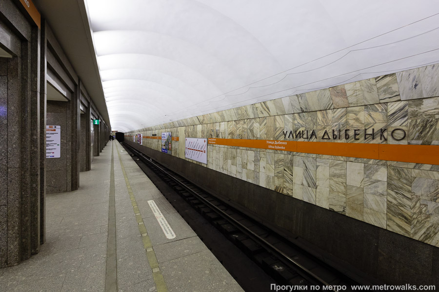 Станция Улица Дыбенко (Правобережная линия, Санкт-Петербург). Боковой зал станции и посадочная платформа, общий вид. Новая фотография, с оранжевой полосой.