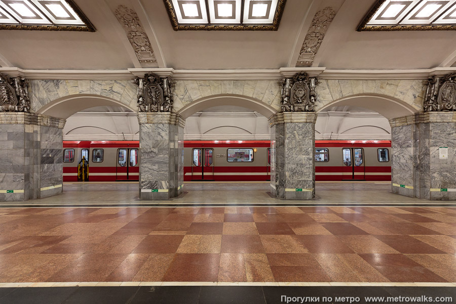 Станция Кировский завод (Кировско-Выборгская линия, Санкт-Петербург). Поперечный вид, проходы между колоннами из центрального зала на платформу. Для пущей цветастости — с поездом.
