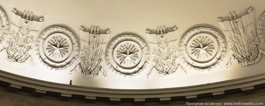 Станция Площадь Восстания (Кировско-Выборгская линия, Санкт-Петербург). Лепнина на куполе эскалаторного зала крупным планом: звёзды, лавровые венки и развевающиеся знамёна.