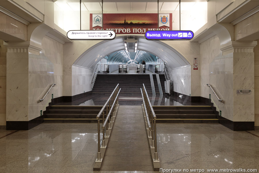 Станция Спортивная (Фрунзенско-Приморская линия, Санкт-Петербург). Выход в город, лестница из центрального зала станции в переходный коридор к эскалаторам. Коридор очень длинный (300 метров под Невой), поэтому в нём установлен каскад из двух групп травелаторов.