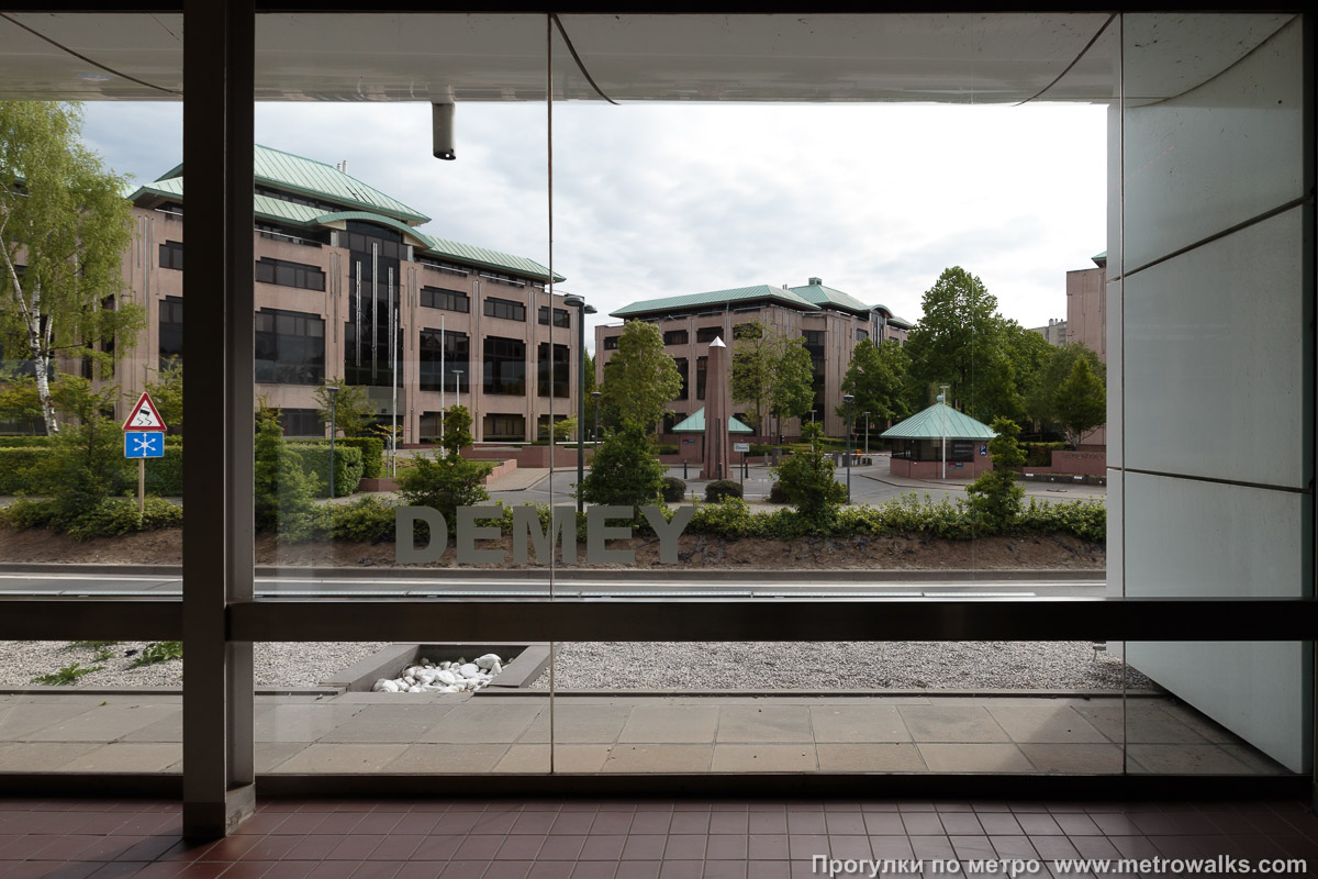 Фотография станции Demey [Дэме́] (линия 5, Брюссель). Станционная стена. Через стеклянные стены станции открывается приятный вид окружающего микрорайона.