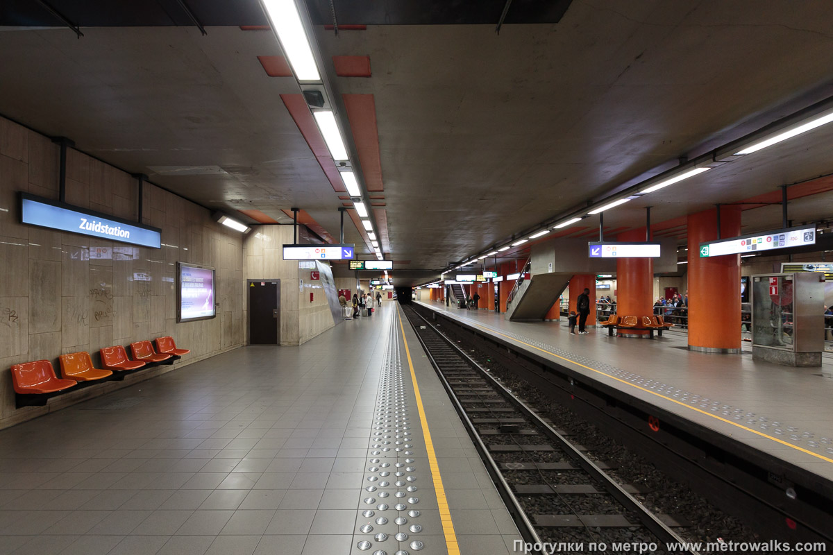 Фотография станции Gare du Midi / Zuidstation [Гар дю Миди́ / Зэ́дстасьо́н] (линия 2 / 6, Брюссель) — второй зал. Продольный вид вдоль края платформы. Оранжевый зал станции — нижний. Сюда прибывают поезда, следующие в восточном направлении (к Porte de Hal).