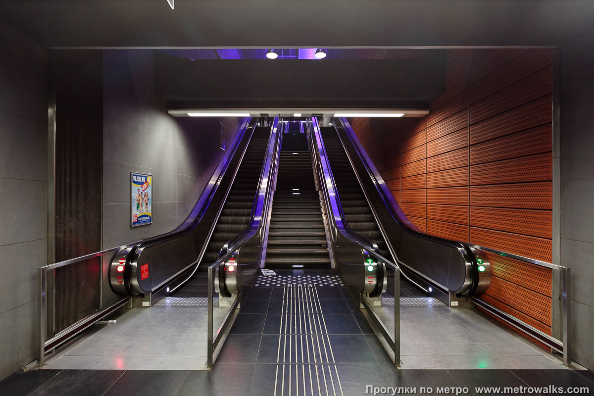 Фотография станции Gare de l'Ouest / Weststation [Гар дё лю́эст / Ве́стстасьо́н] (линия 2 / 6, Брюссель) — второй зал. Выход в город, эскалаторы начинаются прямо с уровня платформы. По этим же эскалаторам можно подняться в верхний зал станции для поездки в обратном направлении.