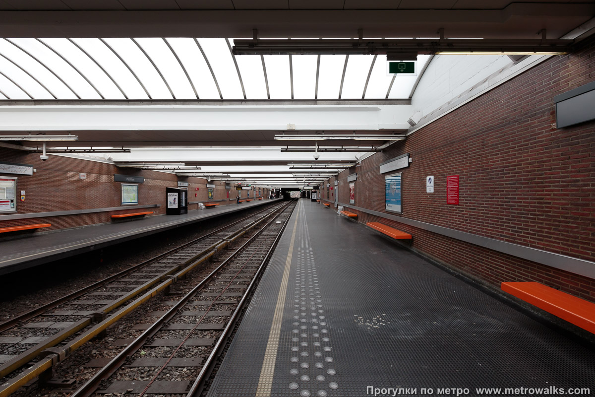 Фотография станции Pétillon [Петийо́н] (линия 5, Брюссель). Продольный вид вдоль края платформы. Днём станция освещена солнечным светом через стеклянный потолок.