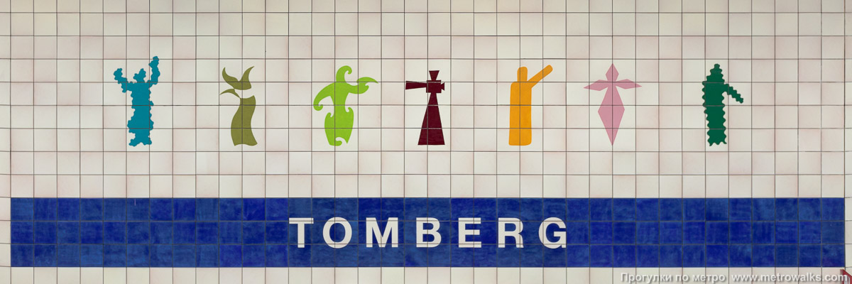 Фотография станции Tomberg [То́мберх] (линия 1, Брюссель). Название станции на станционной стене крупным планом. Версия с оригинальным “алфавитом”.