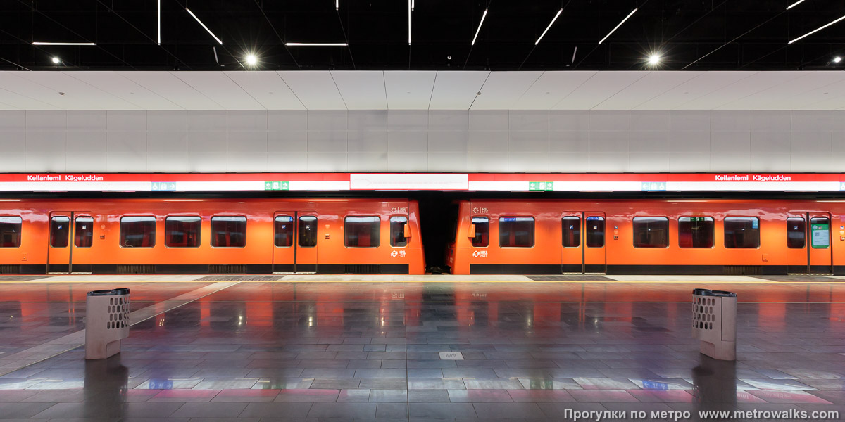 Фотография станции Keilaniemi / Kägeludden [Ке́йланиэ́ми] (Хельсинки). Поперечный вид. Для пущей цветастости — с поездом.