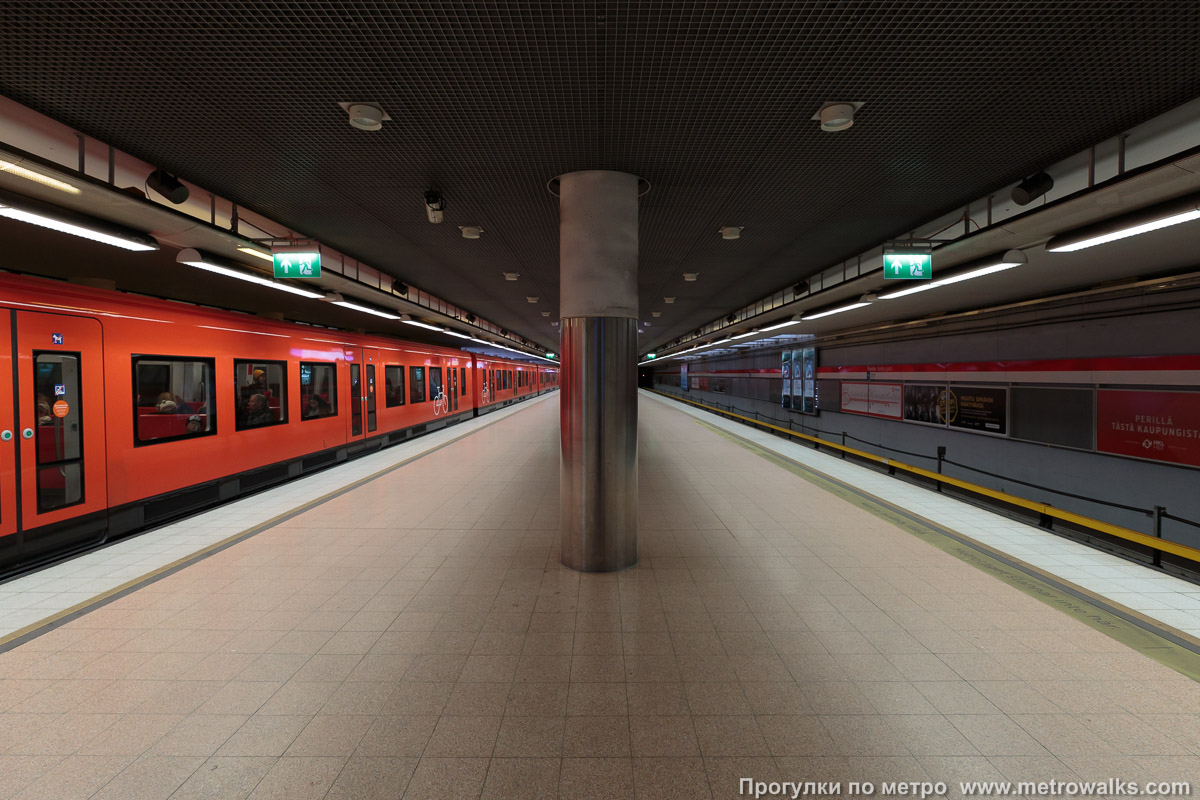 Фотография станции Puotila / Botby Gård [Пуо́тила] (Хельсинки). Продольный вид по оси станции. Для пущей цветастости — с поездом.