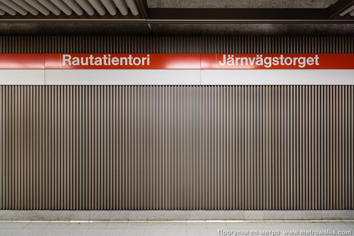 Фотография станции Rautatientori / Järnvägstorget [Ра́утатиэ́нто́ри] (Хельсинки). Название станции на станционной стене крупным планом.