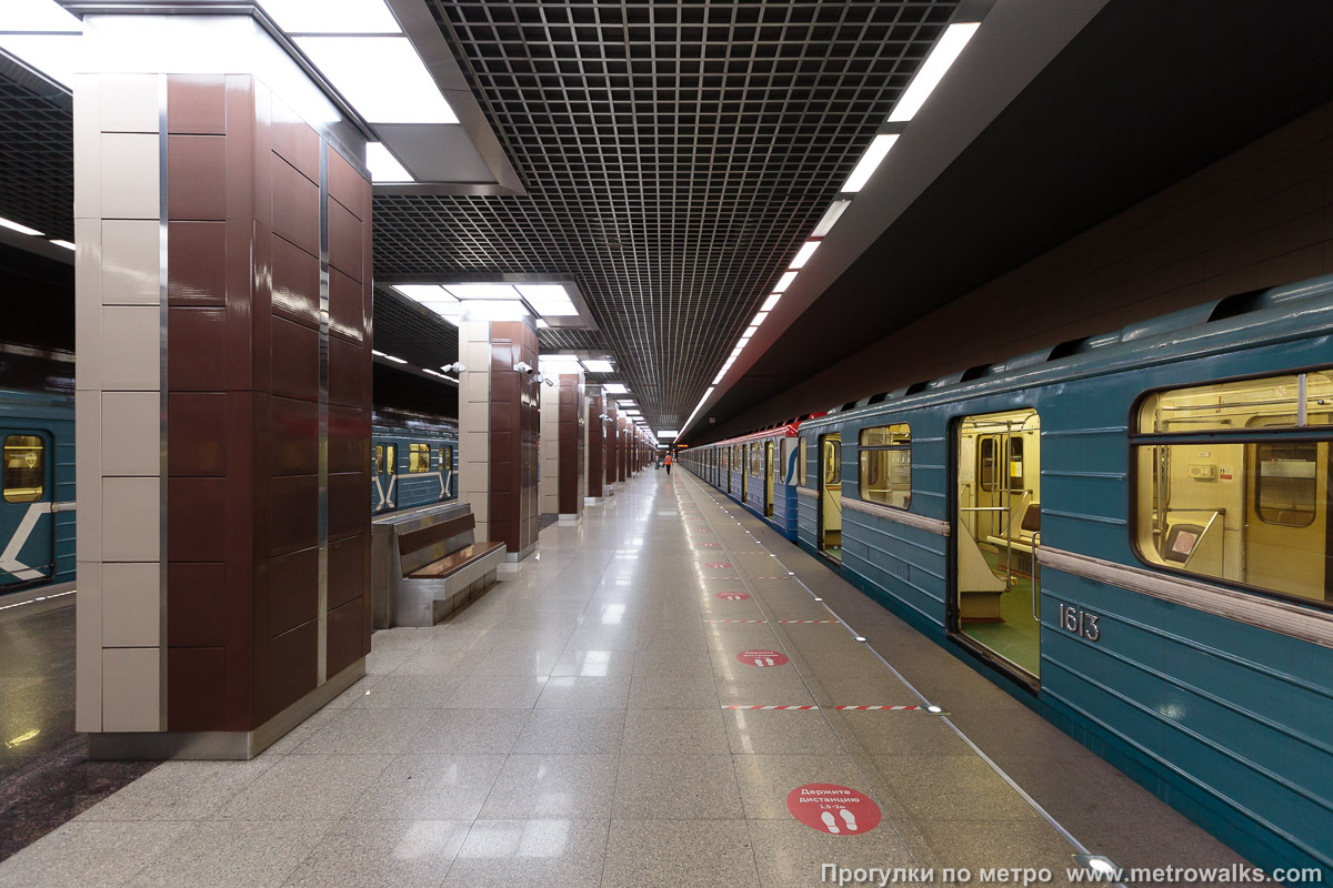 Фотография станции Ховрино (Замоскворецкая линия, Москва). Продольный вид вдоль края платформы. Западная половина станции с бежевой стеной и коричневыми колоннами. Отсюда поезда отправляются в сторону центра.