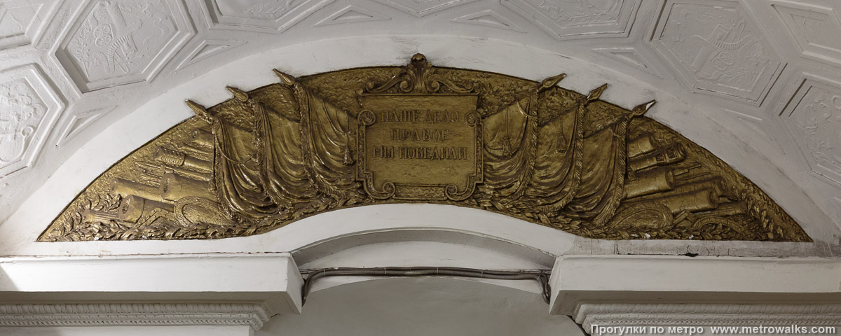 Фотография станции Площадь Революции (Арбатско-Покровская линия, Москва). Начало перехода на Театральную венчает барельеф с лозунгом «Наше дело правое — мы победили». Фотография станции Площадь Революции (Арбатско-Покровская линия, Москва). Начало перехода на Театральную венчает барельеф с лозунгом «Наше дело правое — мы победили».