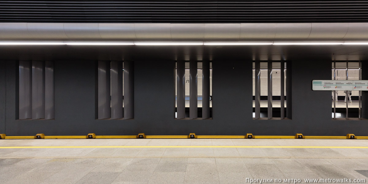 Фотография станции Текстильщики (Большая кольцевая линия, Москва). Поперечный вид. Шторки в проёмах унылой межпутевой стены установлены параллельно, а кажущаяся хаотичность панелей — это лишь иллюзия от широкого угла зрения.