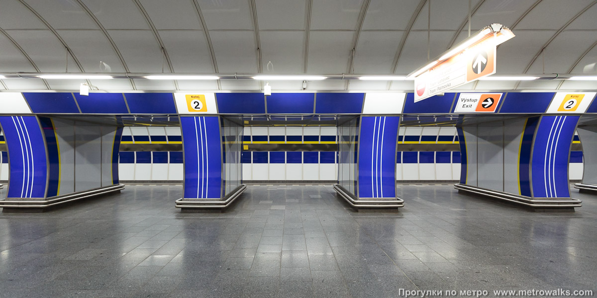 Фотография станции Kolbenova [Колбенова] (линия B, Прага). Поперечный вид, проходы между пилонами из центрального зала на платформу.