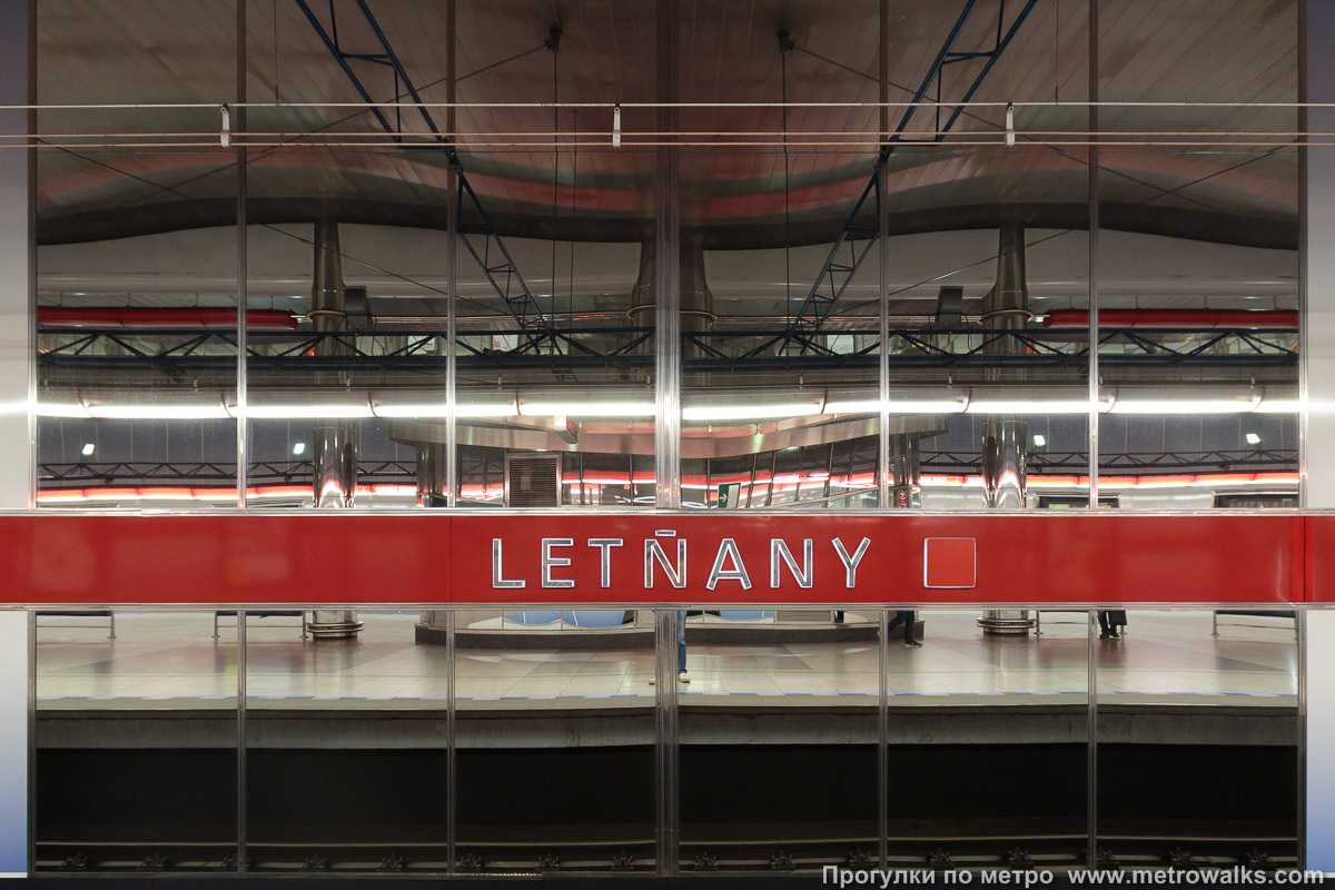 Фотография станции Letňany [Летня́ны] (линия C, Прага). Декоративное оформление путевой стены крупным планом. Путевые стены украшены гигантскими панорамными зеркалами.