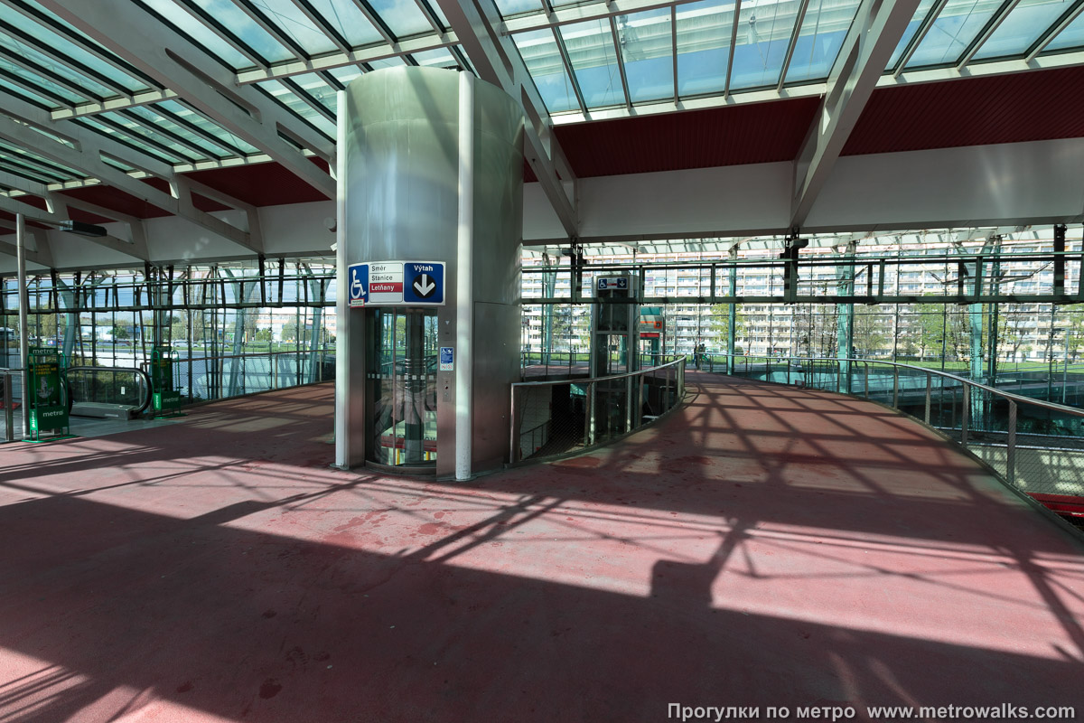 Фотография станции Střížkov [Стрши́жков] (линия C, Прага). Внутри вестибюля станции, общий вид. Вестибюль состоит только из переходного мостика, лифта и эскалаторов, а валидаторы билетов расположены внизу, на платформах.