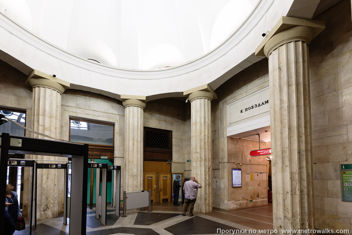 Фотография станции Кировский завод (Кировско-Выборгская линия, Санкт-Петербург). Внутри вестибюля станции, общий вид. Ракурс со стороны касс. Парадный вид со стороны входной группы перекрыт нагромождением серых конструкций.