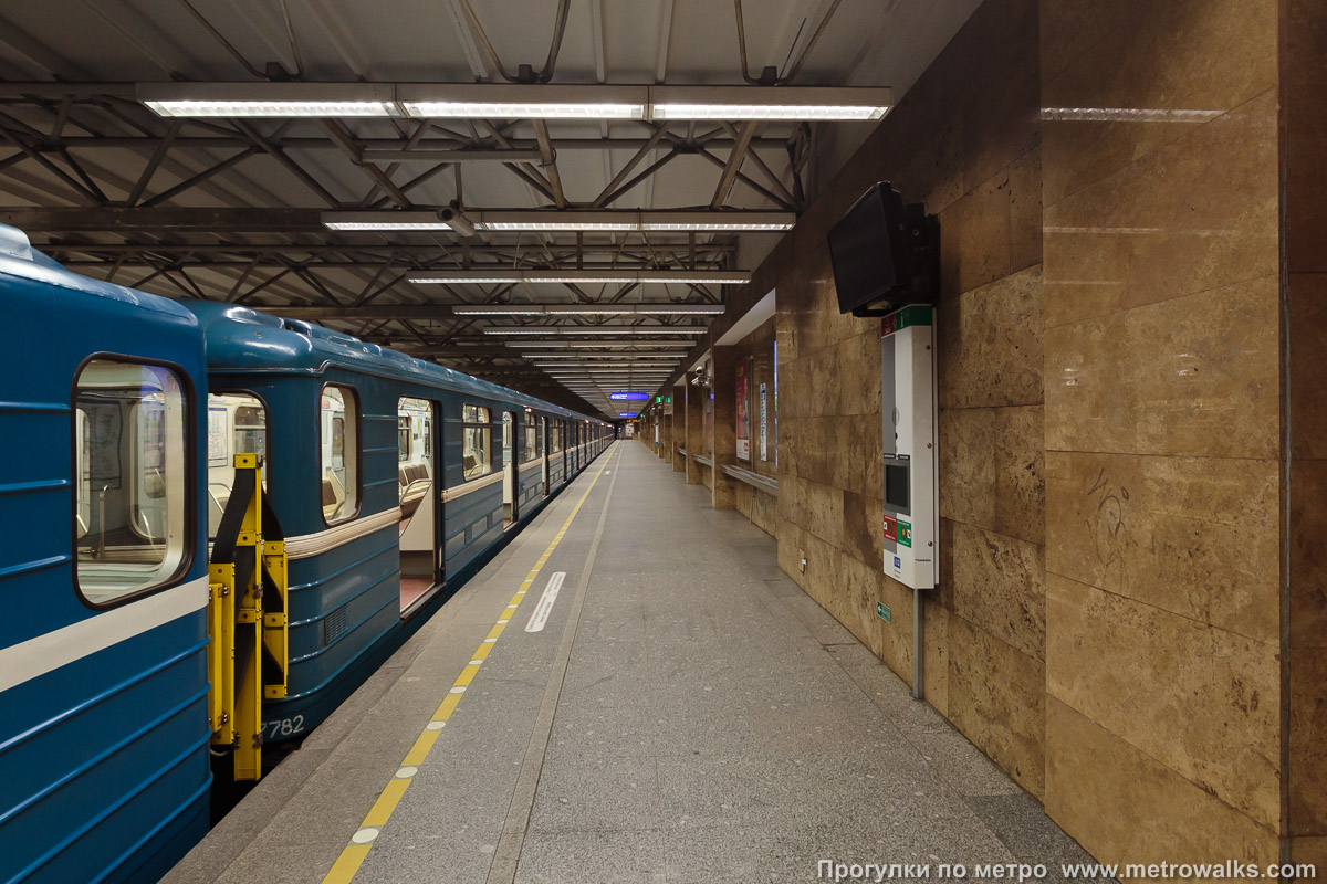 Фотография станции Купчино (Московско-Петроградская линия, Санкт-Петербург). Продольный вид вдоль края платформы. Для разнообразия — с поездом.