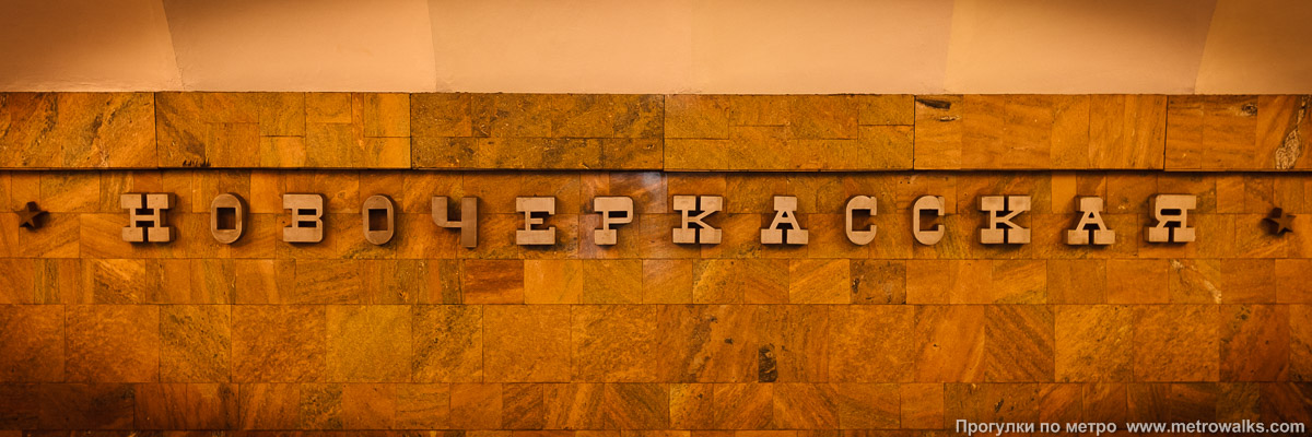 Фотография станции Новочеркасская (Правобережная линия, Санкт-Петербург). Название станции на путевой стене крупным планом. Исторический снимок: буква «Ч», не совпадающая по стилю с остальными буквами названия, просуществовала с 1992 до 2011 года.