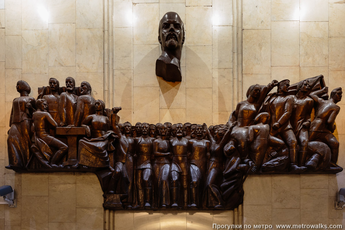 Фотография станции Обухово (Невско-Василеостровская линия, Санкт-Петербург). Декоративное оформление глухого торца. Горельеф, посвящённый революционной борьбе пролетариев-обуховцев, возглавляемый нетипично острым профилем Ленина (скульптор — А. А. Федосов).