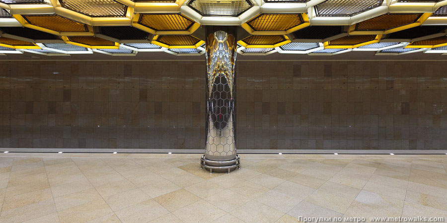Станция Ботаническая (Екатеринбург). Поперечный вид, проходы между колоннами из центрального зала на платформу. Ракурс с колонной посередине. Колонна выглядит как гигантское дерево, крона которого — пчелиные соты.