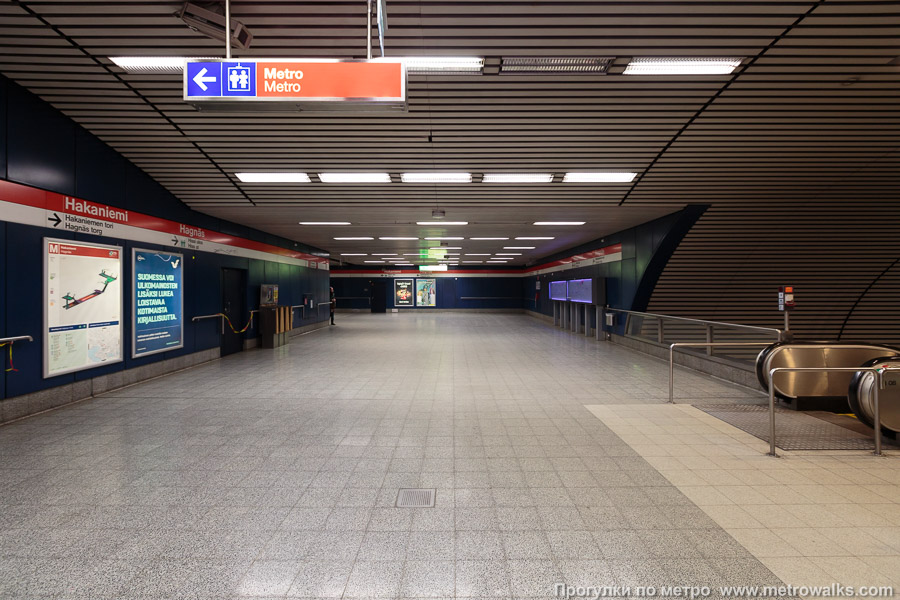 Станция Hakaniemi / Hagnäs [Ха́каниэ́ми] (Хельсинки). Промежуточный зал между двумя группами эскалаторов. От эскалаторов с платформы (справа) к эскалаторам в подземный вестибюль под площадью Hakaniemi.