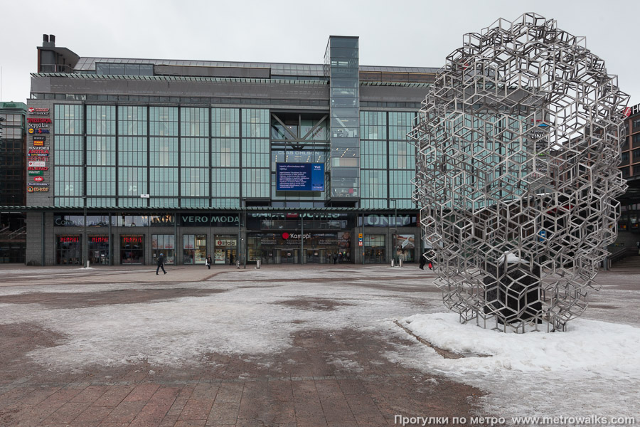 Станция Kamppi / Kampen [Ка́мппи] (Хельсинки). Наземный вестибюль станции встроен в торговый комплекс. Вход в метро через торговый комплекс «Kamppi» со стороны проспекта Маннергейма наиболее известен среди приезжих.