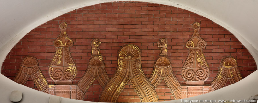 Станция Боровицкая (Серпуховско-Тимирязевская линия, Москва). Над переходом на Арбатскую — керамическое панно с изображением декора нижнего яруса Спасской башни с белокаменными арками и башенками.