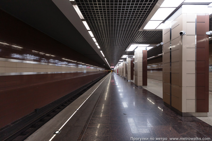 Станция Ховрино (Замоскворецкая линия, Москва). Продольный вид вдоль края платформы. Восточная половина станции с коричневой стеной и бежевыми колоннами. Сюда прибывают поезда из центра.