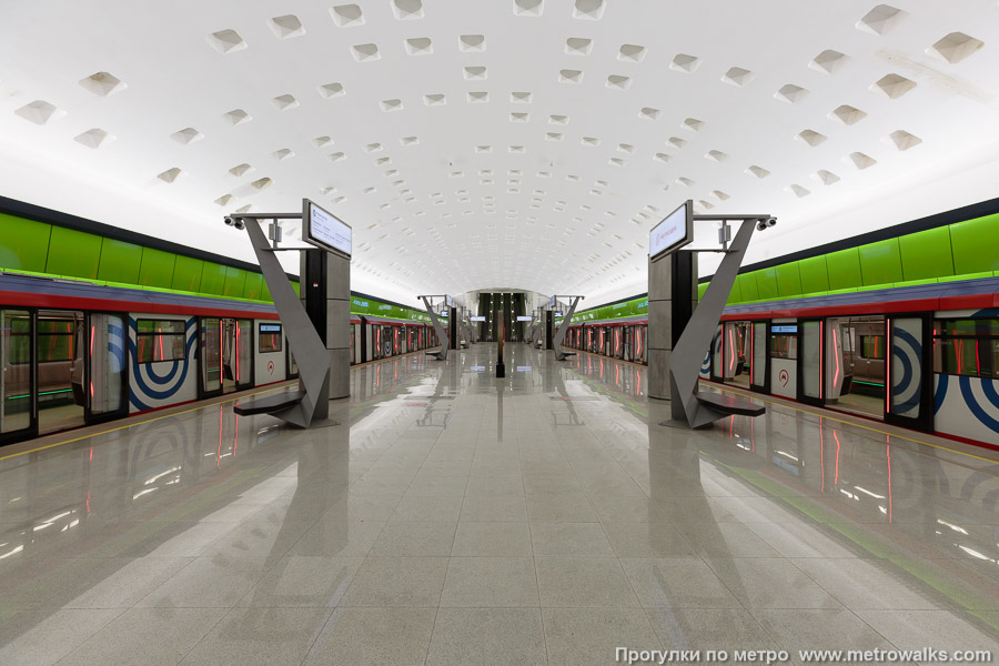 Станция Новомосковская (Троицкая линия, Москва). Общий вид по оси станции от глухого торца в сторону выхода. Для пущей цветастости — с поездами.