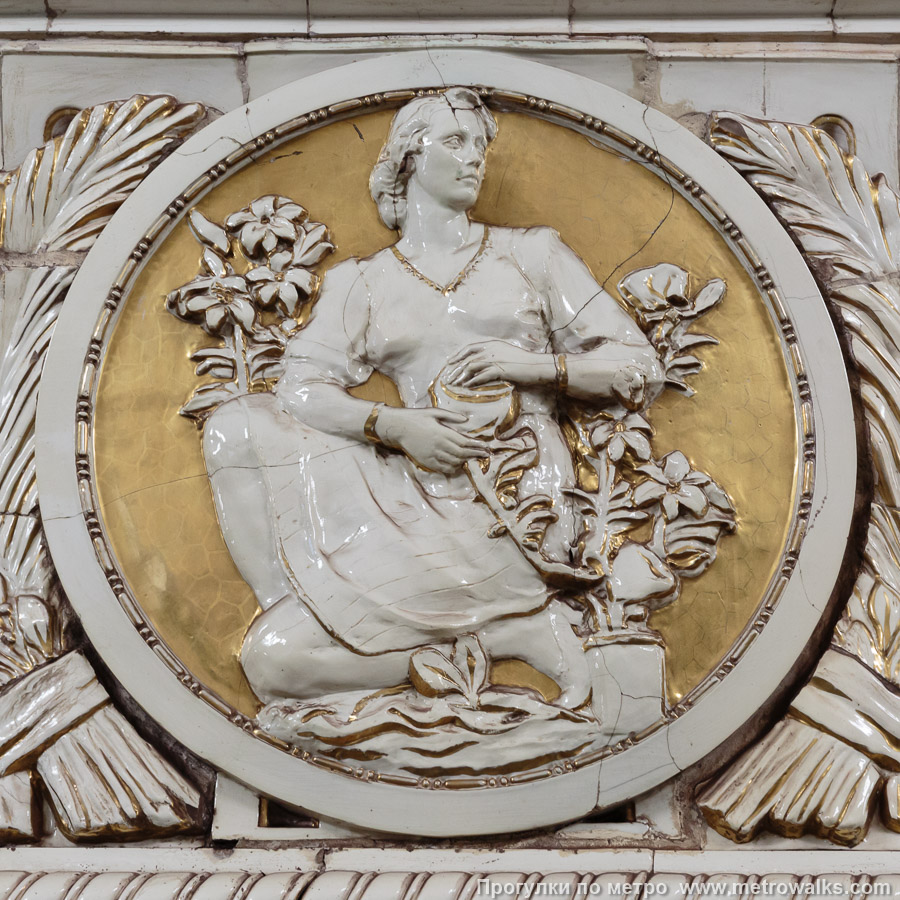 Станция Проспект Мира (Кольцевая линия, Москва). Фарфоровые медальоны на пилонах изображают сцены садовых и ботанических работ. № 1 (по первому, внутреннему пути, слева от спуска на станцию) — девушка с цветами в горшках.