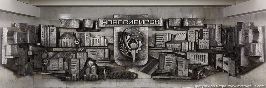 Станция Площадь Гарина-Михайловского (Дзержинская линия, Новосибирск). Украшение над спуском на станцию. Горельеф с символическими изображениями различных объектов Новосибирска.