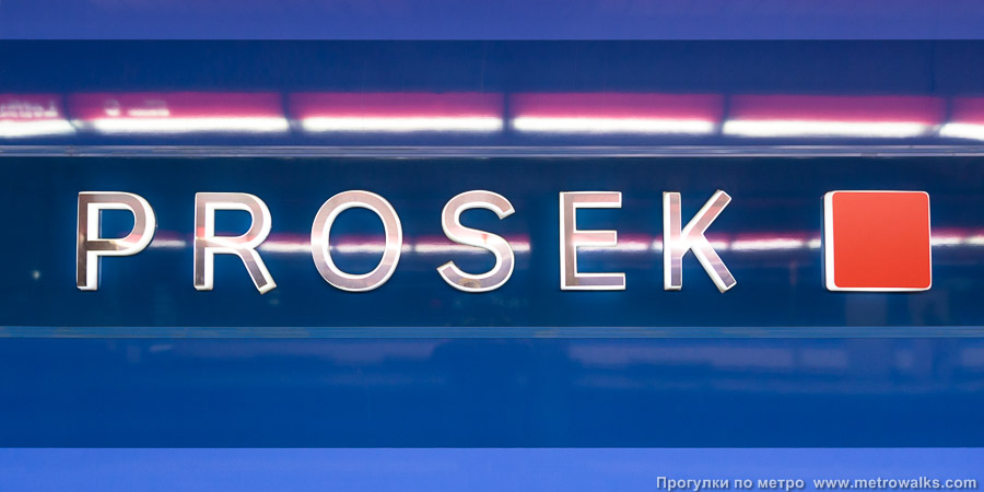 Станция Prosek [Про́сэк] (линия C, Прага). Название станции на станционной стене крупным планом. Синяя версия.