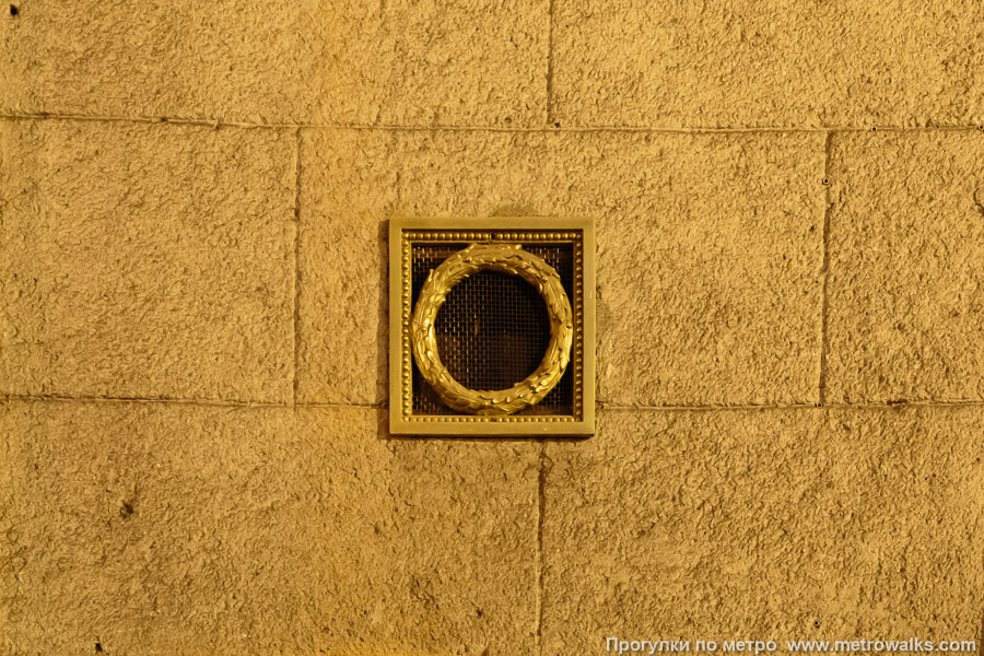 Станция Автово (Кировско-Выборгская линия, Санкт-Петербург). Декоративная мини-решётка в виде дубового венка, скрывающая громкоговоритель. Это типовой элемент многих станций первой очереди.