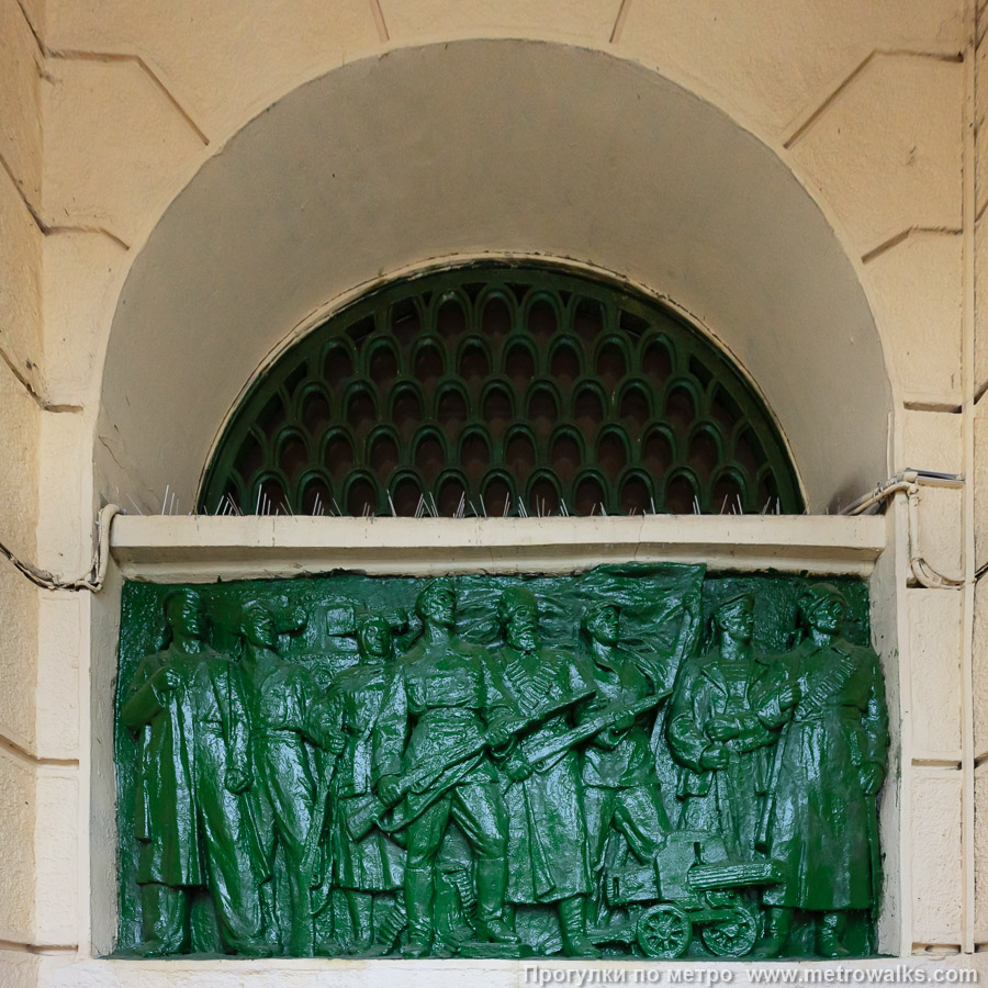 Станция Автово (Кировско-Выборгская линия, Санкт-Петербург). Архитектурное оформление вестибюля. Барельеф с воинами у входной группы слева.