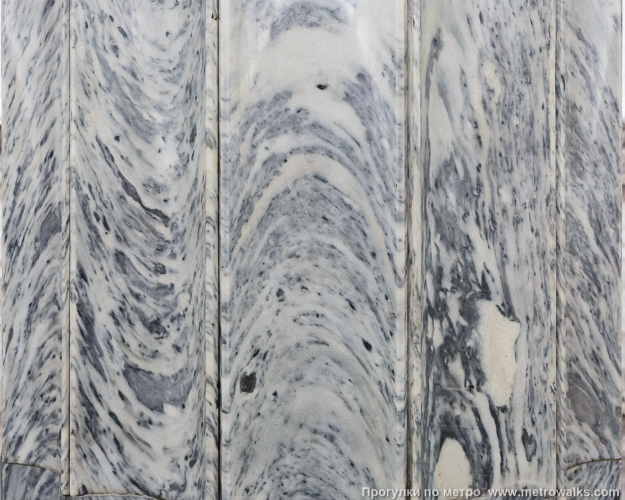 Станция Балтийская (Кировско-Выборгская линия, Санкт-Петербург). Со стороны центрального зала облицовка колонн выполнена с полукруглыми бороздками, что превратило прямые прожилки мрамора в изгибающиеся, как бегущие волны Балтийского моря.