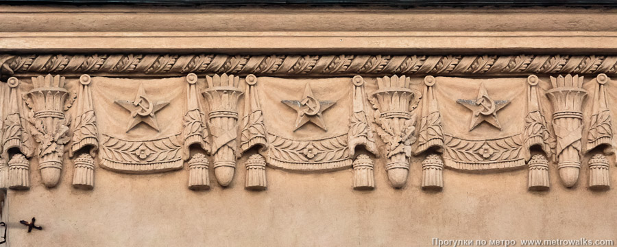 Станция Кировский завод (Кировско-Выборгская линия, Санкт-Петербург). Архитектурное оформление вестибюля. Прикарнизный фриз с типовыми символами эпохи СССР — звёздами, серпами-и-молотами, знамёнами, факелами, дубовыми ветвями.