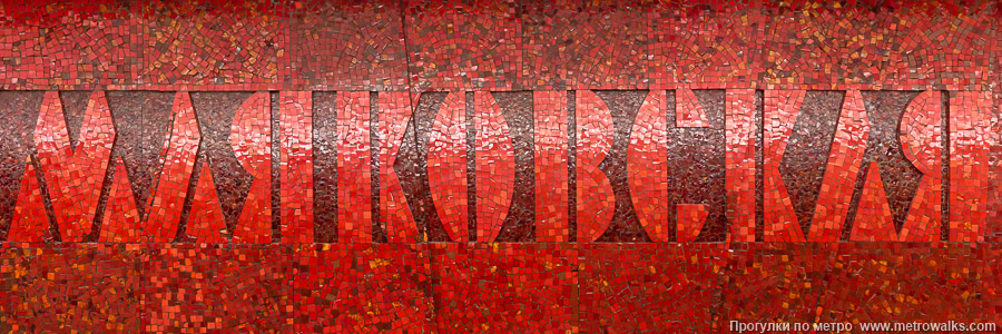Станция Маяковская (Невско-Василеостровская линия, Санкт-Петербург). Название станции на станционной стене крупным планом. Выполнено капитально в стене в виде сложной мозаики из красной смальты.