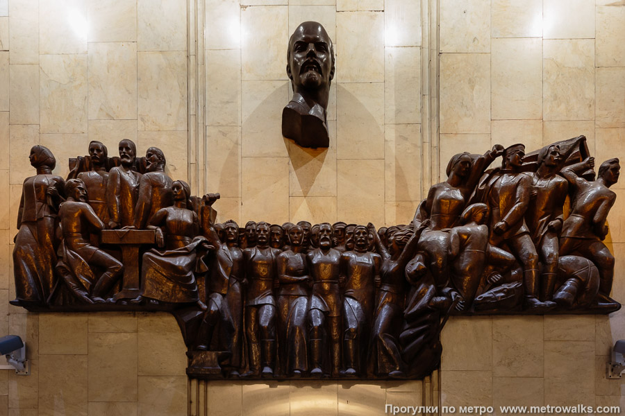 Станция Обухово (Невско-Василеостровская линия, Санкт-Петербург). Декоративное оформление глухого торца. Горельеф, посвящённый революционной борьбе пролетариев-обуховцев, возглавляемый нетипично острым профилем Ленина (скульптор — А. А. Федосов).