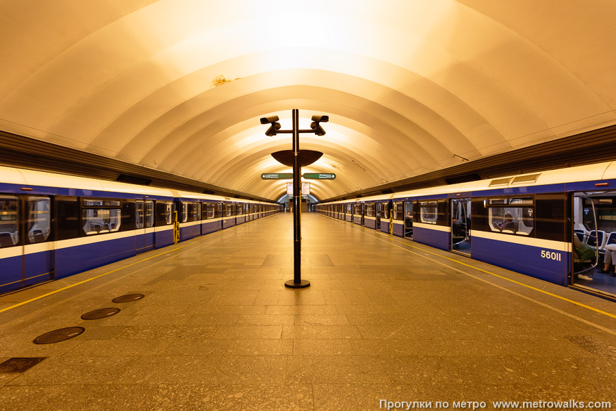 Станция Обухово (Невско-Василеостровская линия, Санкт-Петербург). Общий вид по оси станции от входа в сторону глухого торца. Для оживления пустынной станции — с двумя синими поездами модели «Нева».