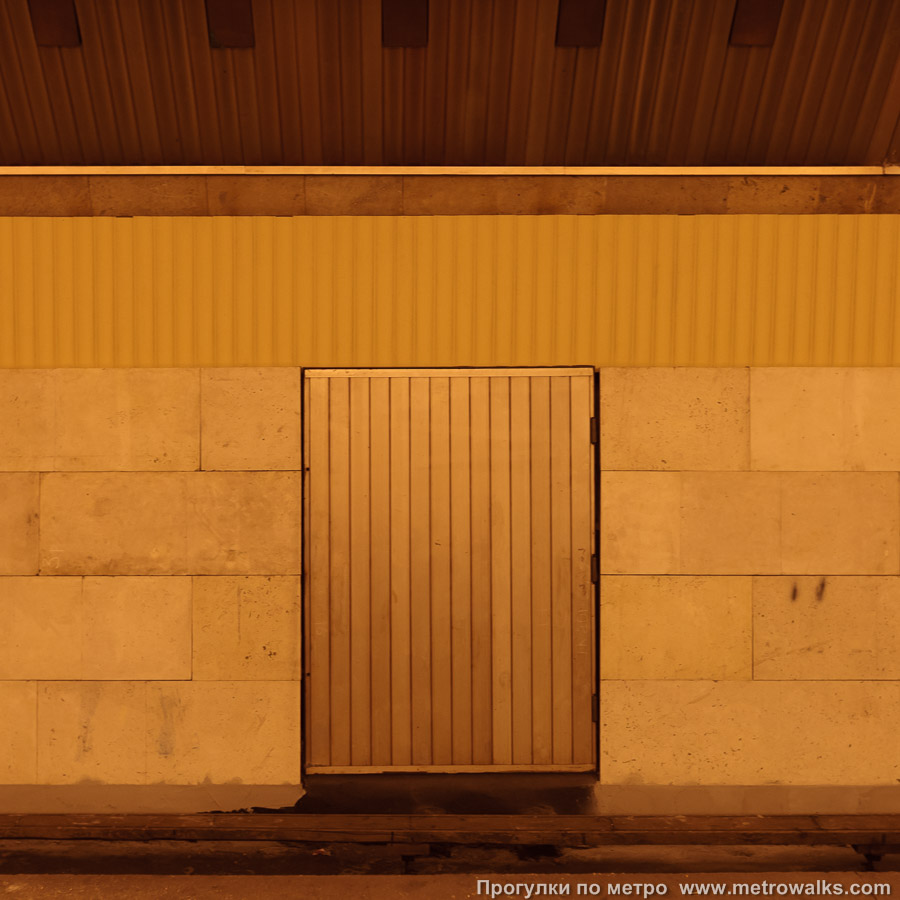Станция Политехническая (Кировско-Выборгская линия, Санкт-Петербург). Декоративная технологическая дверь в стене. Исторический снимок: облицовка уже заменена, а дверь стоит ещё оригинальная, из анодированного алюминия.