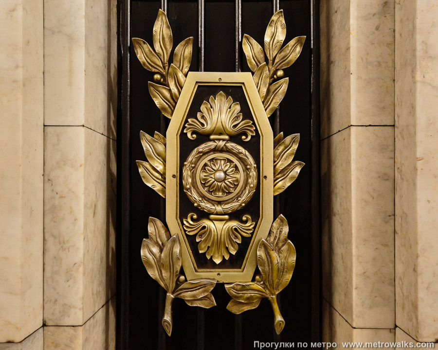 Станция Пушкинская (Кировско-Выборгская линия, Санкт-Петербург). Деталь декоративного оформления пилона: бронзовый щиток.