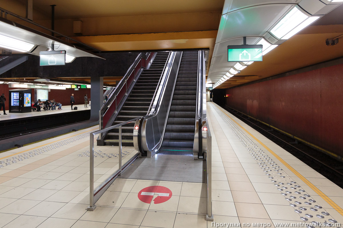 Фотография станции Beekkant [Бе́ккант] (линия 5, Брюссель). Выход в город, эскалаторы начинаются прямо с уровня платформы. Во избежание столпотворения входные и выходные эскалаторы находятся в разных частях платформы.