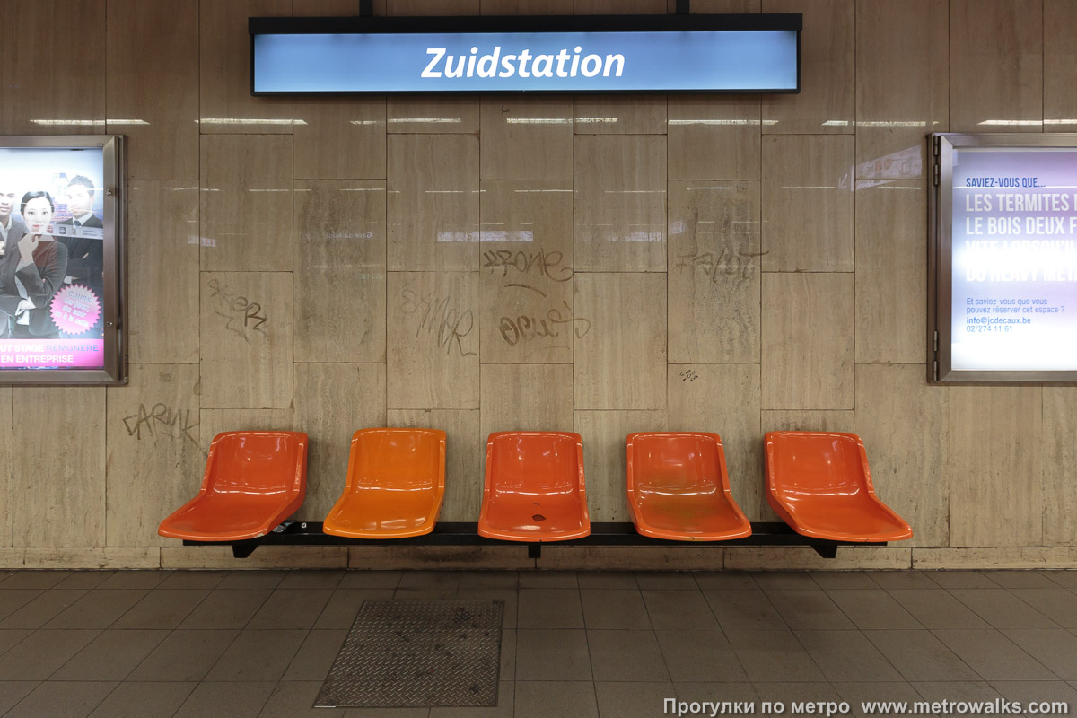 Фотография станции Gare du Midi / Zuidstation [Гар дю Миди́ / Зэ́дстасьо́н] (линия 2 / 6, Брюссель) — второй зал. Скамейка. Горизонт здесь не завален, это табло с названием станции криво висит.