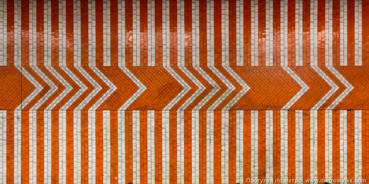 Фотография станции Pannenhuis [Па́ннэнха́йс] (линия 2 / 6, Брюссель). Путевая стена. Путевая стена облицована мелкими керамическими прямоугольниками разных размеров, формирующими простой геометрический орнамент.